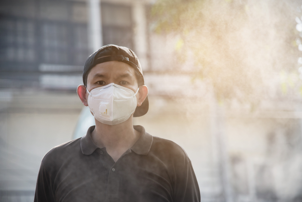 asian man wearing N95 mask outdoors during haze
