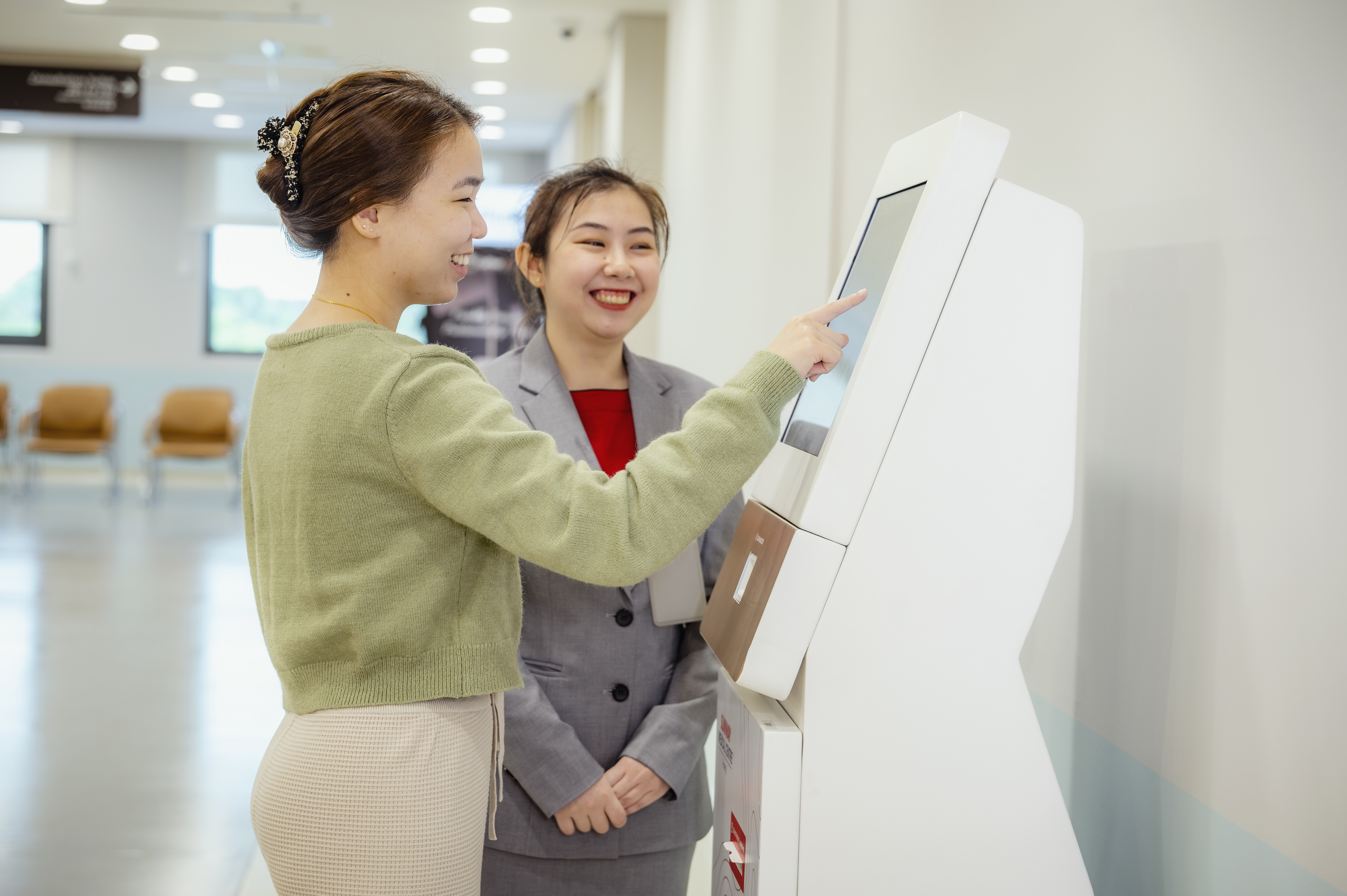 SMCP customer service assisting customer on queue ticket machine