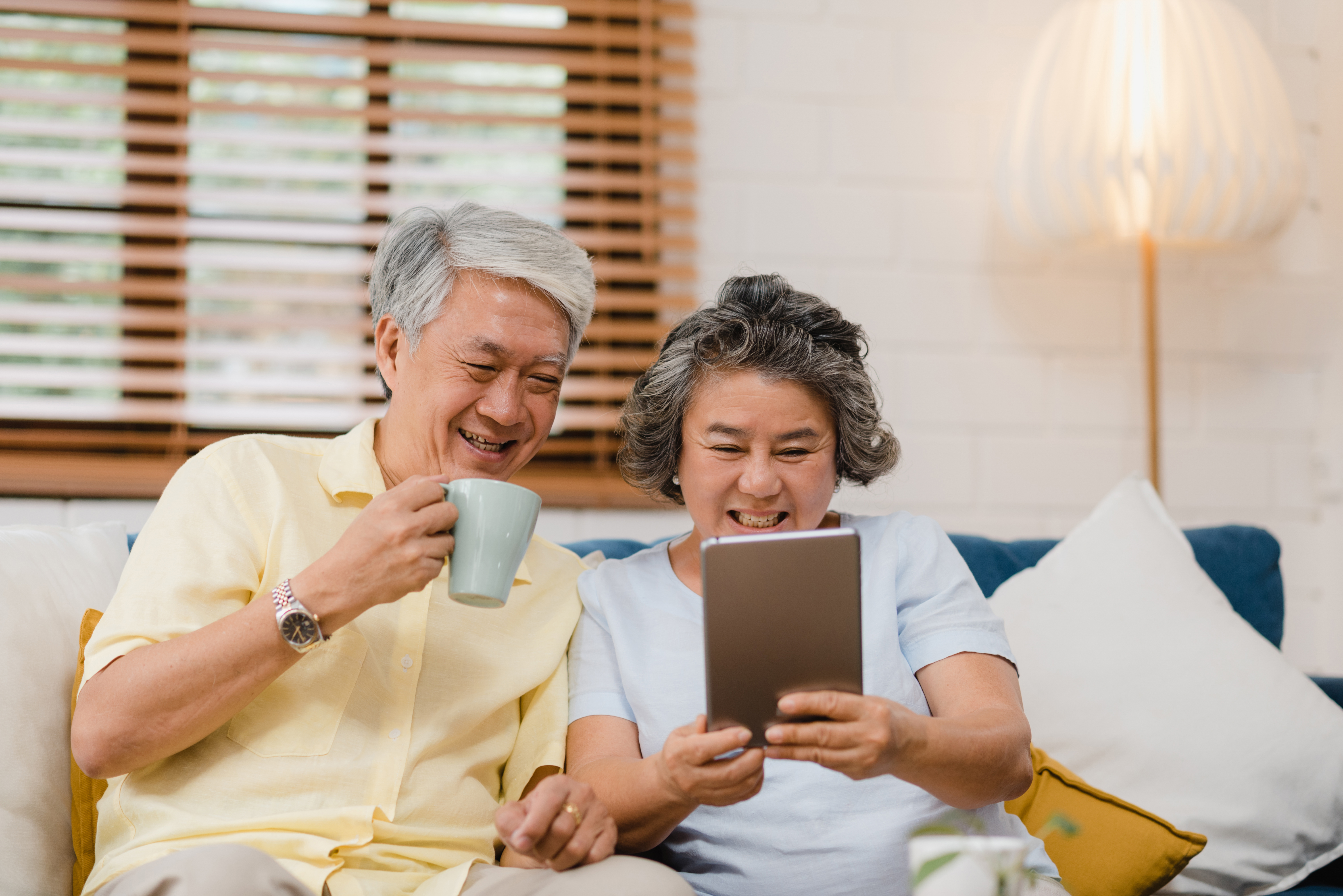 asian elderly couple looking at tablet at home