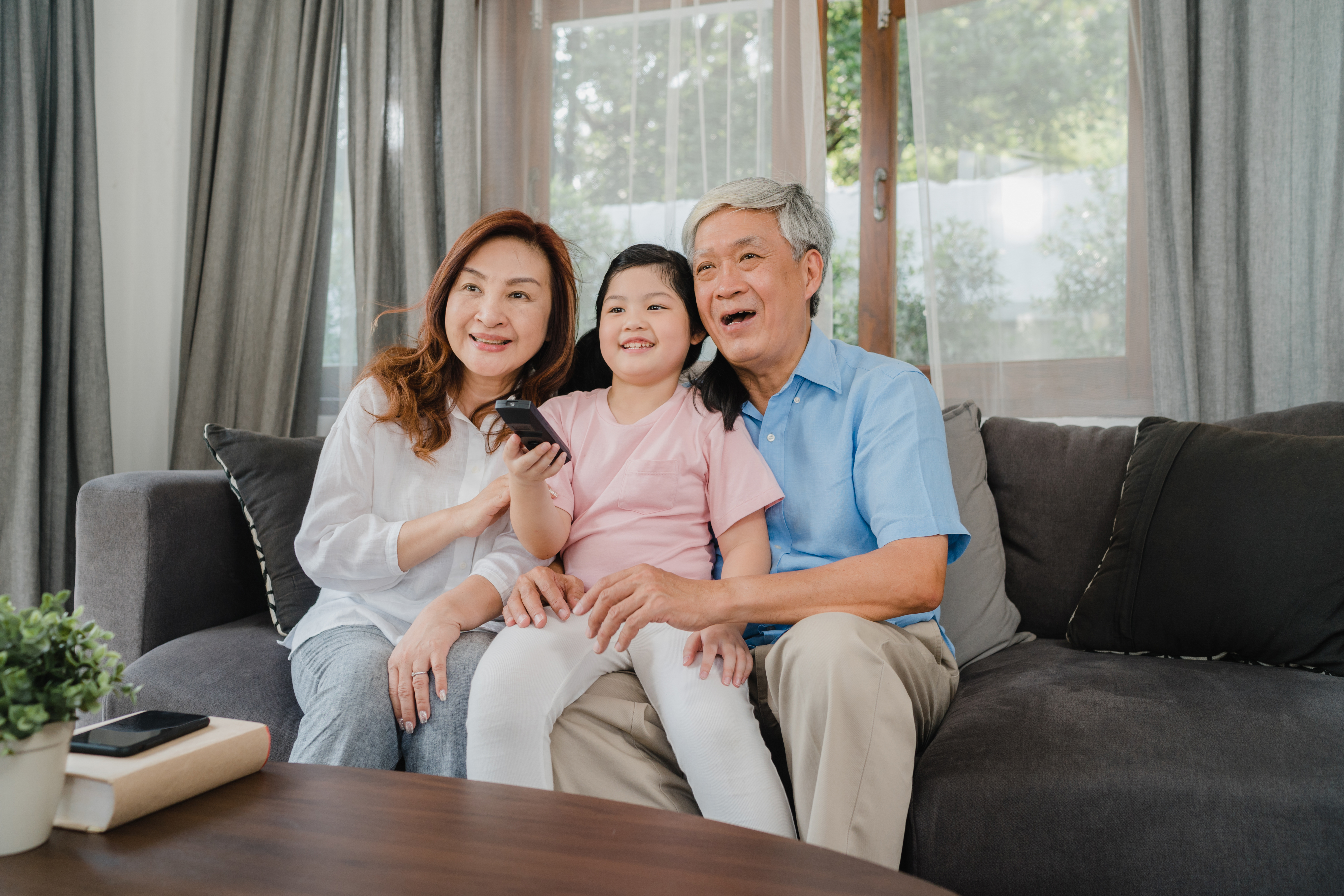 elderly asian couple and young child at home indoors