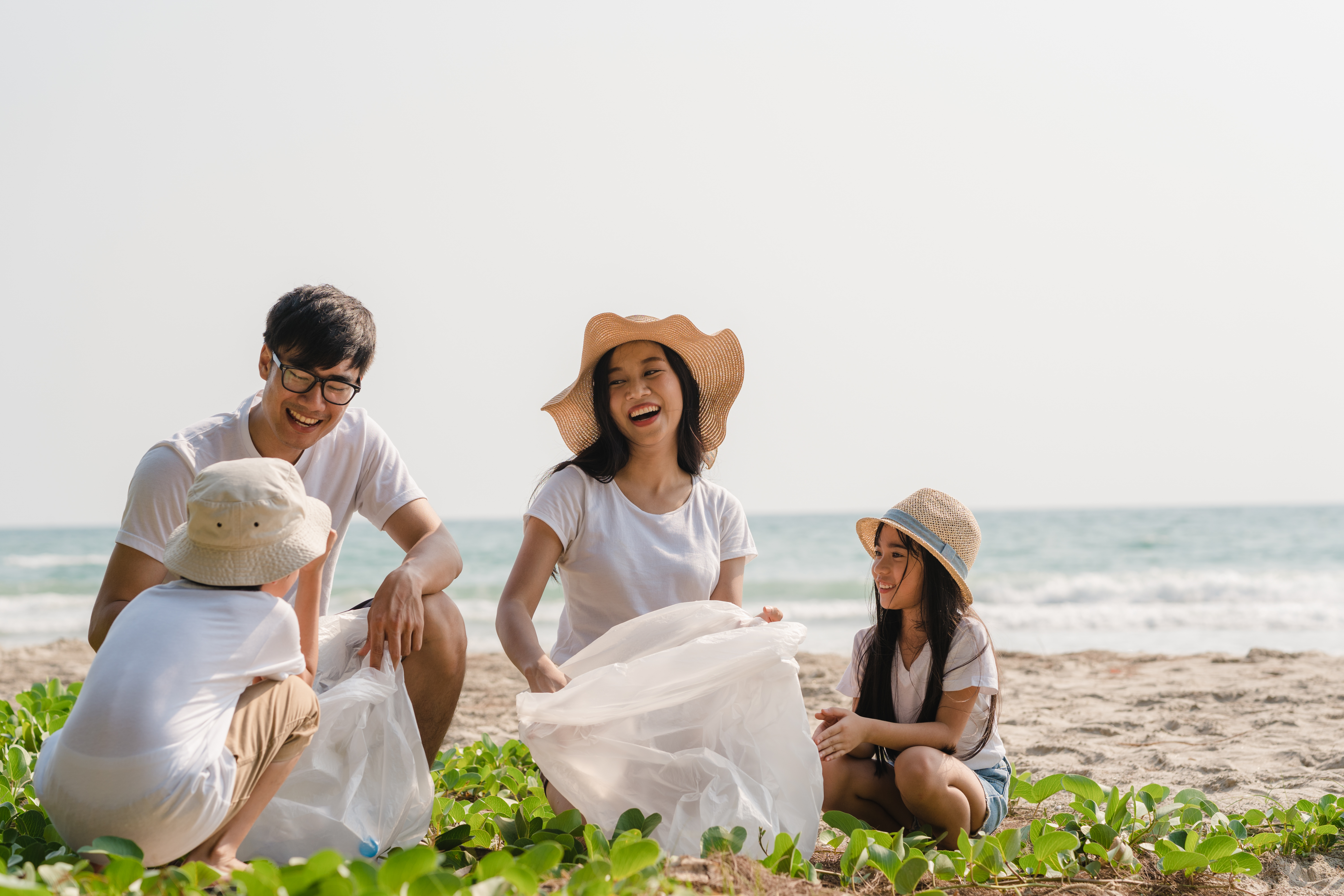 asian young happy family playing by the beach