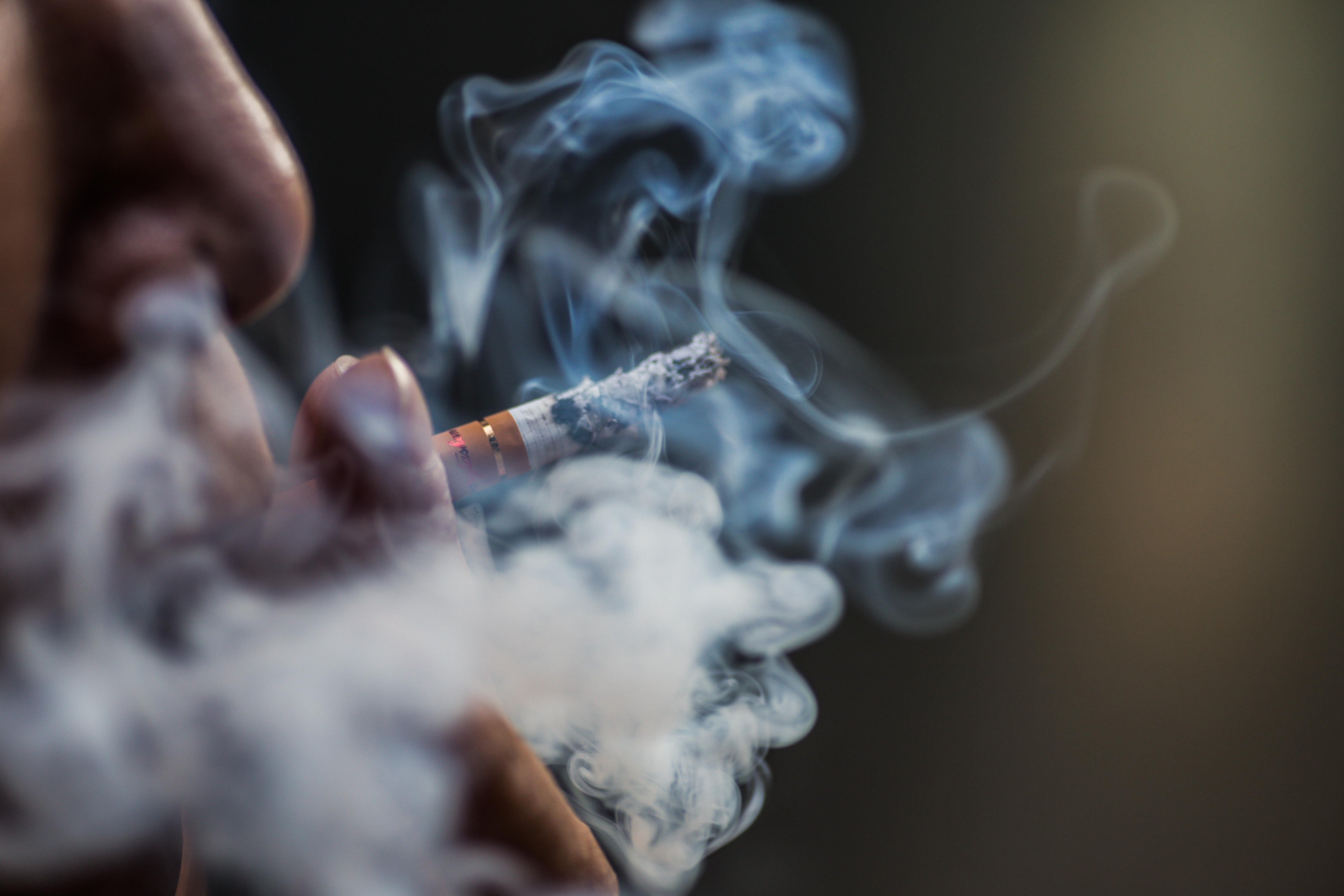 man smoking cigarette with alot of smoke around