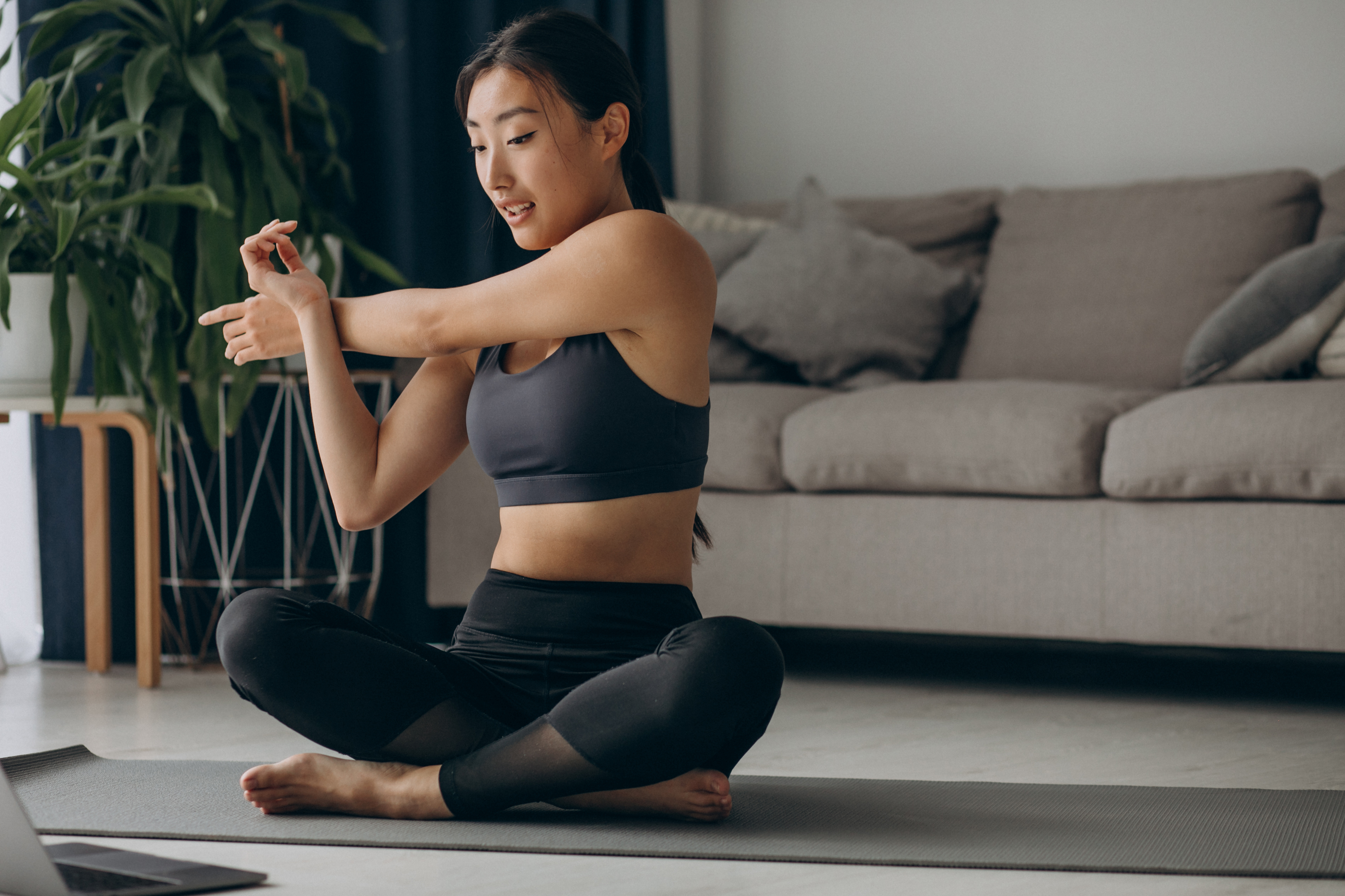 asian woman stretching on yoga mat