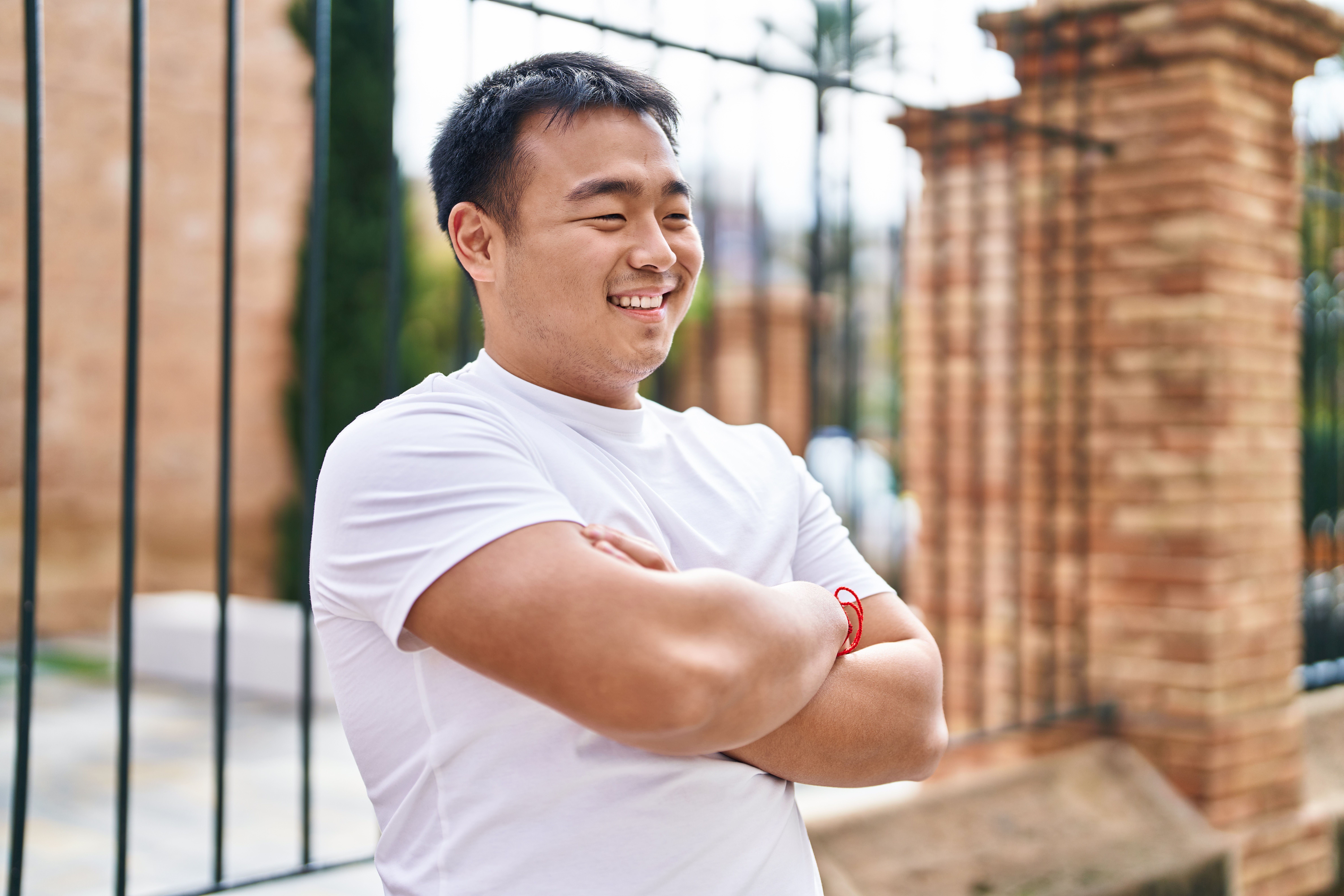 chinese man standing with arm crossed smilling